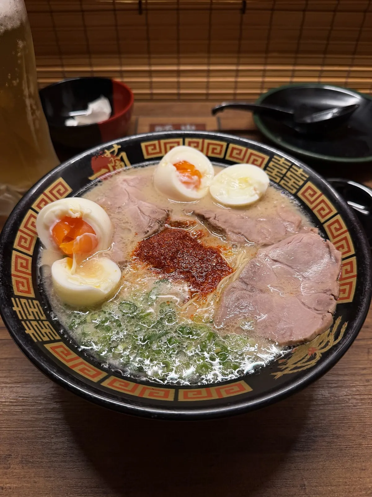 Bowl of Ichiran tonkotsu ramen with chashu, egg and red spice paste, photographed at an Ichiran shop in Tokyo