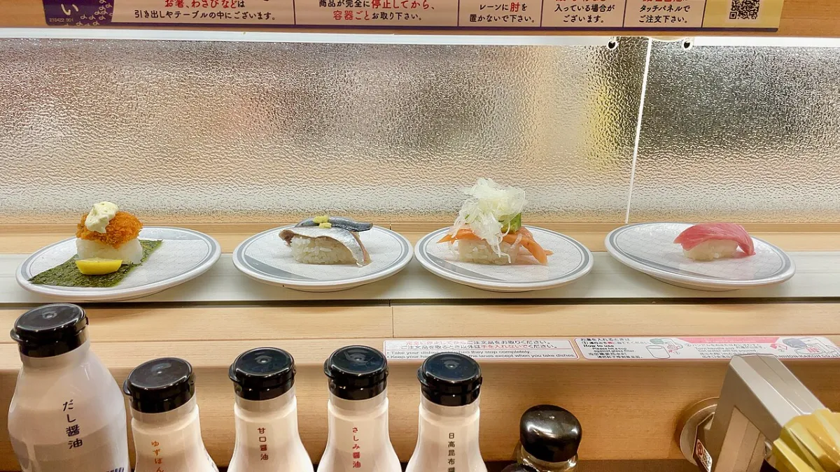Color-coded plates of nigiri on the conveyor lane at Hama Sushi, one of the best sushi chains in Japan