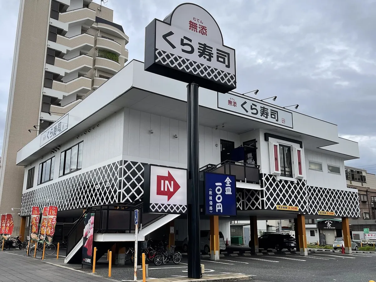 Kura Sushi storefront in Japan with the chain's black and white lattice facade
