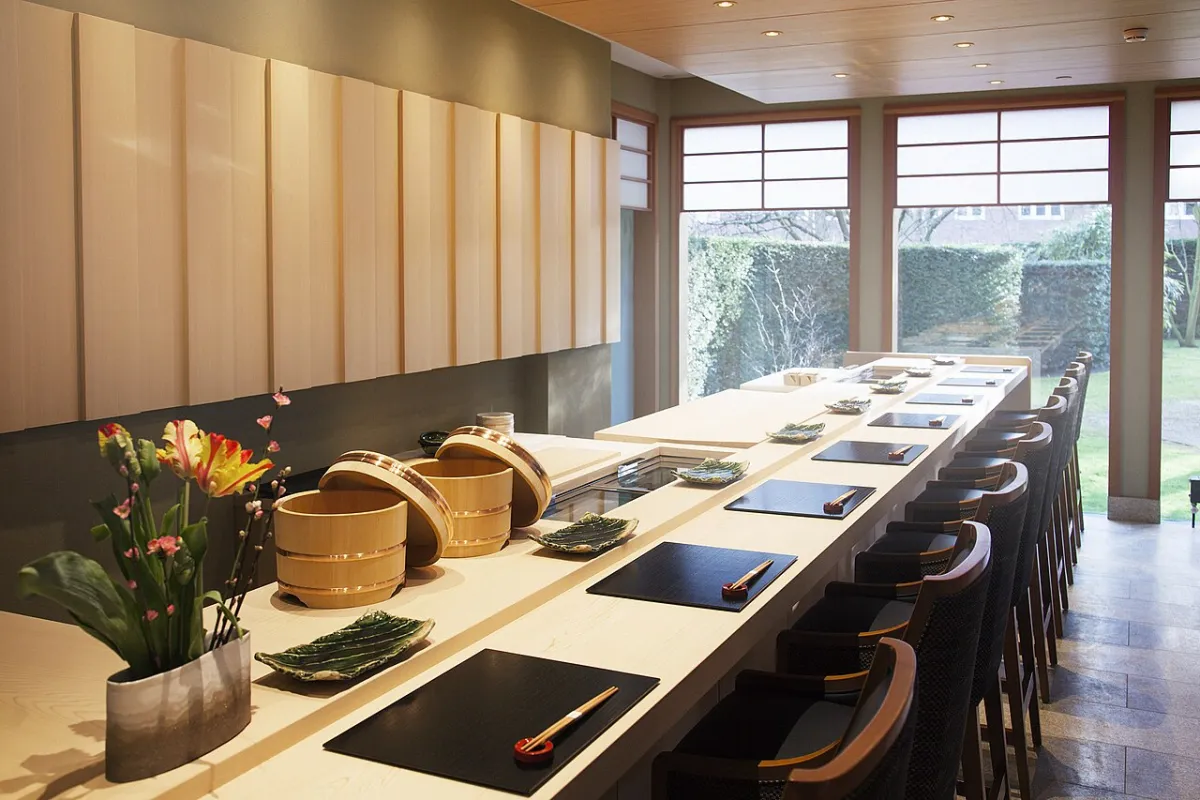 Sushi counter set with wooden rice tubs, lacquer trays and chopsticks, the setting of an omakase sushi meal